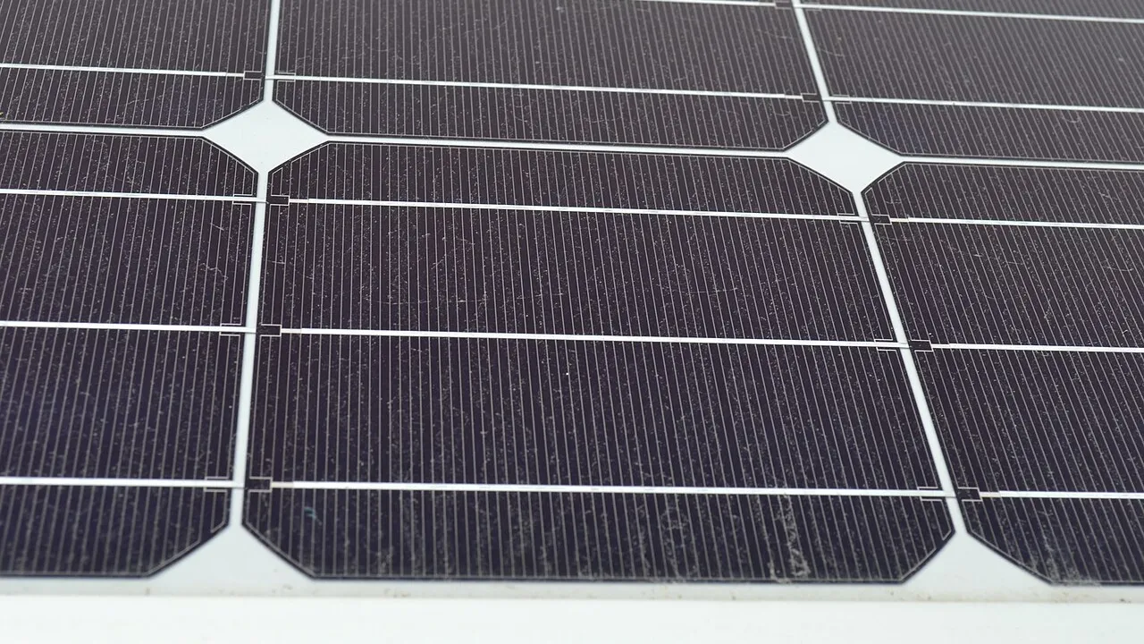Close de células fotovoltaicas em módulo solar mostrando barramentos metálicos