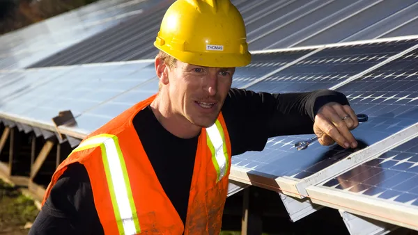 Técnico de energia solar instalando painéis fotovoltaicos no telhado