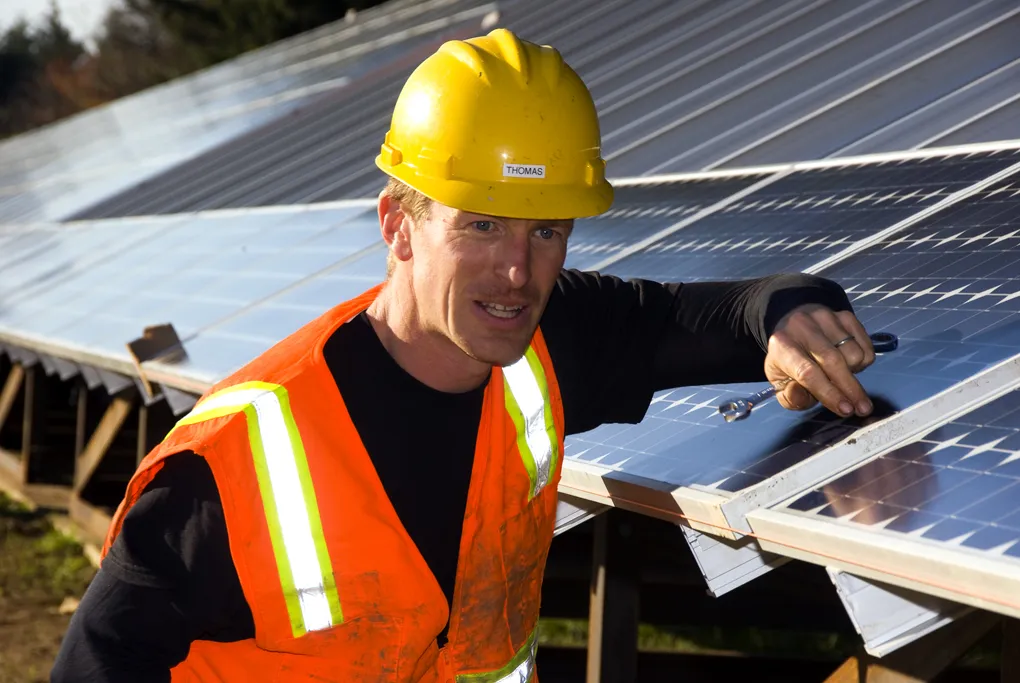 Técnico de energia solar instalando painéis fotovoltaicos no telhado