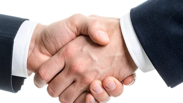 Aperto de mãos em fechamento de contrato comercial, simbolizando acordo entre cliente e integradora solar