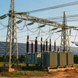 Usina solar conectada a subestação com linhas de transmissão ao fundo, representando a geração distribuída de maior porte