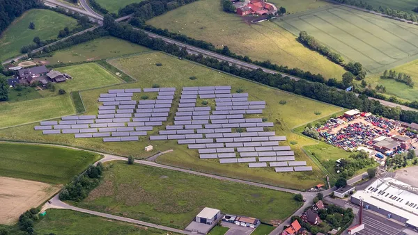 Vista aérea de usina fotovoltaica industrial com fileiras de painéis solares