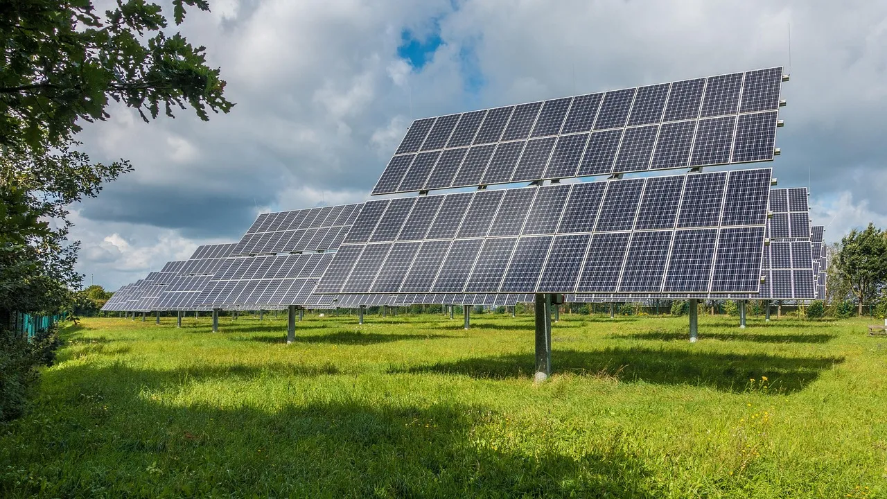Painéis fotovoltaicos instalados em campo aberto com céu nublado ao fundo